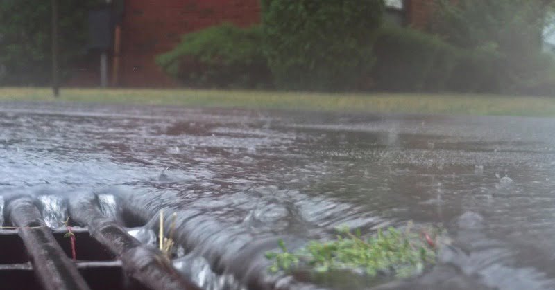 heavy rain pouring down a gutter