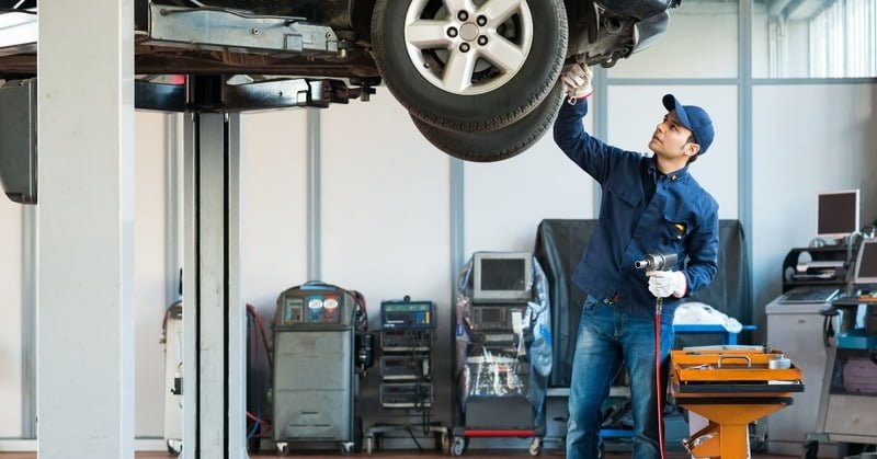 a mechanic trying to fix a car's steering system