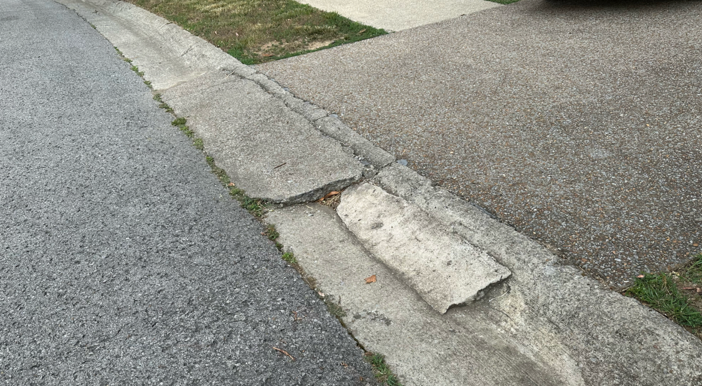 An asphalt curb ramp that is degrading.