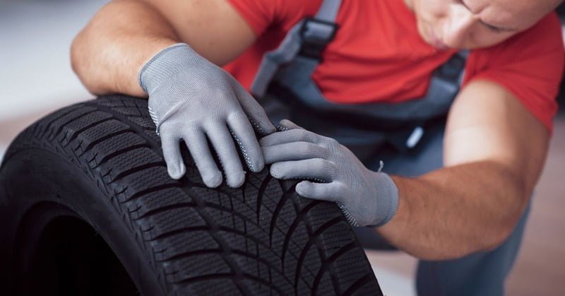 a car owner inspecting a tire