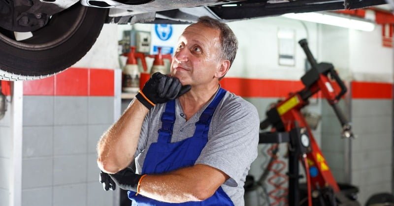 A Mechanic That 039 S Under A Car Being Repaired Thinking a mechanic that's under a car being repaired thinking