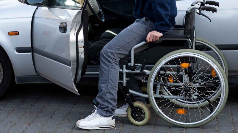Disabled Driver Getting Into A Car At Driveway