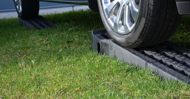 plastic curb ramp being placed under a car