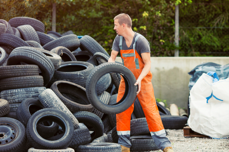 Recycling worker sorting scrap tires