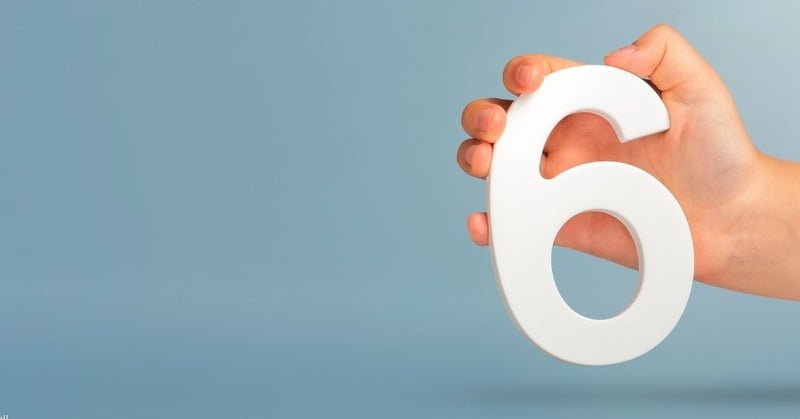 number 6 being held by a hand