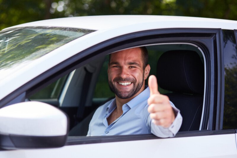 Man Driving Car And Doing Thumbs Up Gesture
