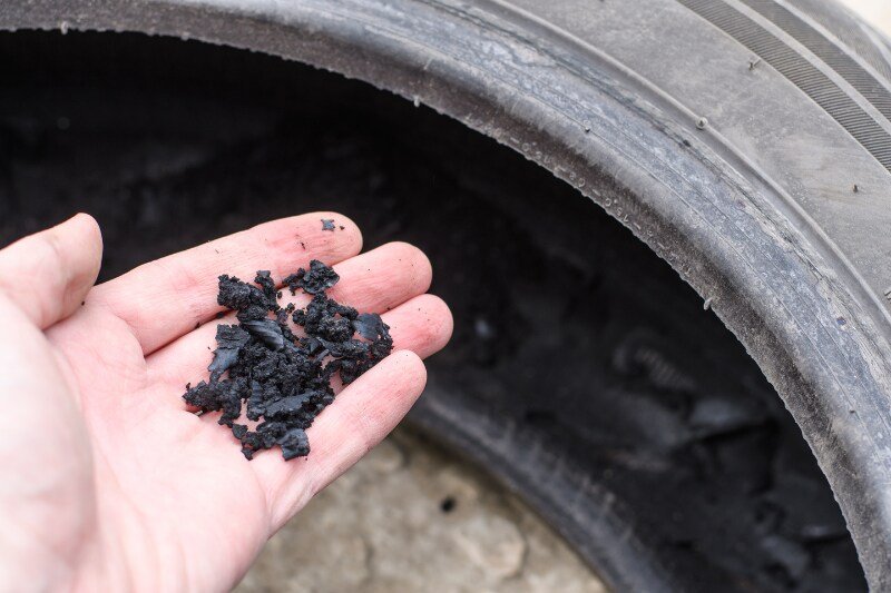 Rubber Crumb From An Old Torn Car Tire In A Man's Hand