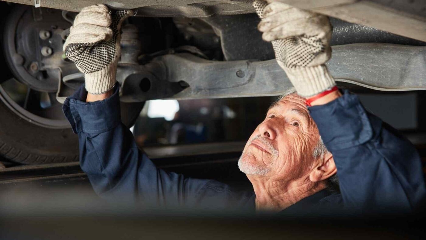 Car Mechanic At Auto Repair Under The Car