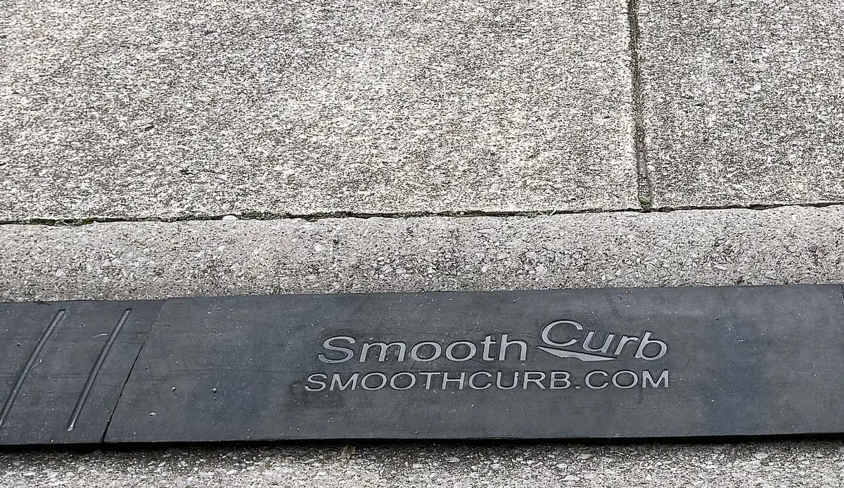 Durable Real Close-up of the real Smooth Curb ramp installed on a curb, showing the embossed logo and dense rubber texture