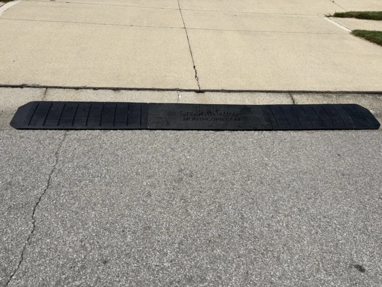 Three-section Smooth Curb rubber ramp installed along a concrete driveway curb